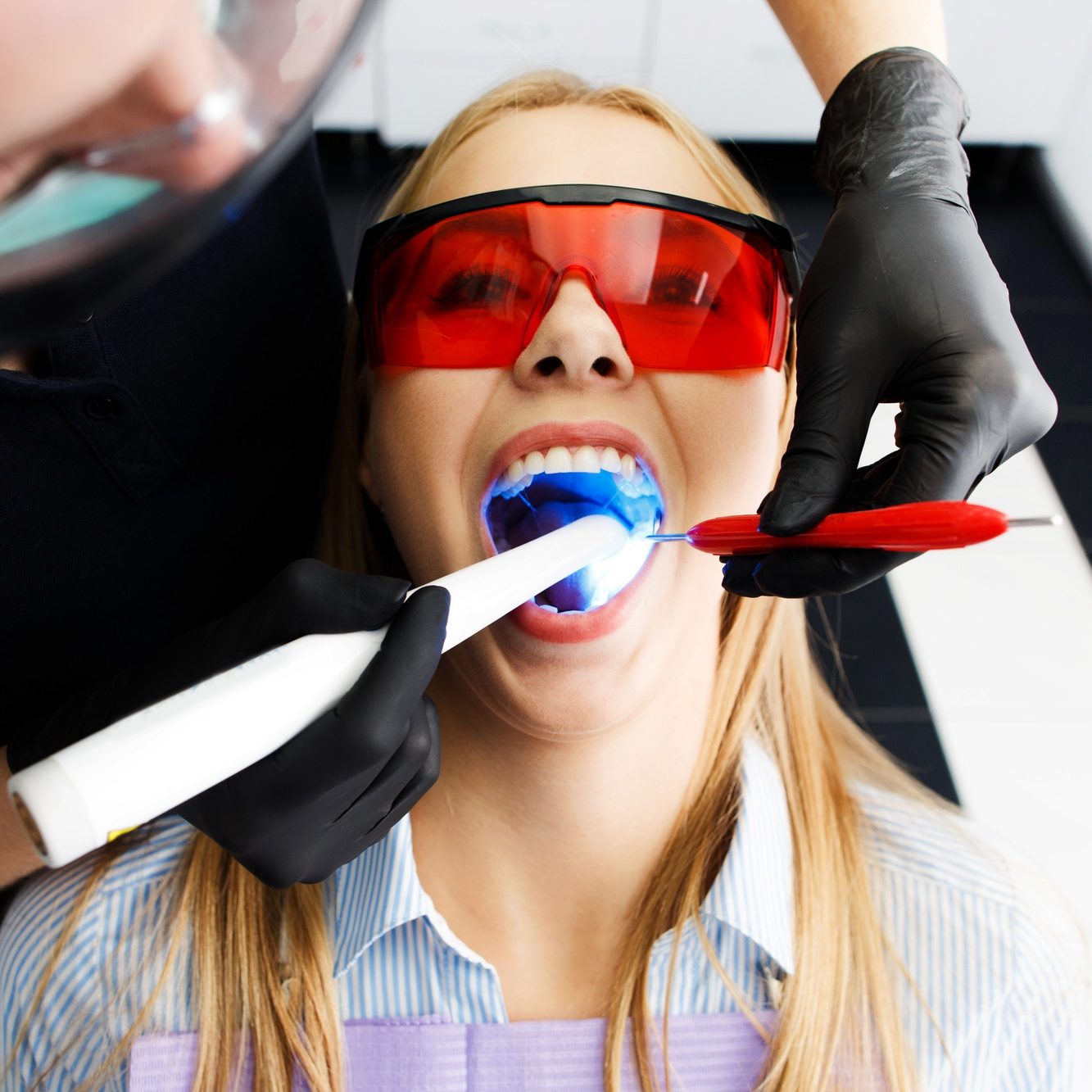 patient-red-glasses-sits-chair-dentist-office-while-doctor-whiten-her-teeth patient-red-glasses-sits-chair-dentist-office-while-doctor-whiten-her-teeth